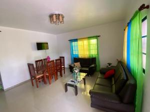 een woonkamer met een bank en een tafel en stoelen bij Oasis de paz in Jarabacoa