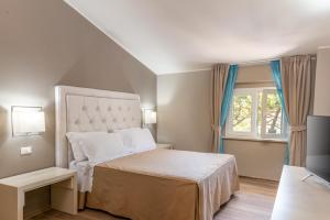 Hotel Villa Bolgheri في مارينا دي كاستانييتو كاردوتشي: غرفة نوم بها سرير ونافذة +31 صورة