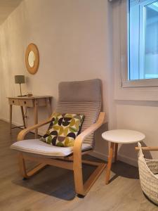 a chair with a pillow and a table in a room at AdA Apartamento in Santiago de Compostela