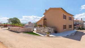 a house on a dirt road next to a building at Villa Vias Oliveti by Villas Holiday in Baldaši