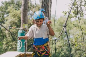a young boy in a helmet on a zip line at Camiral Golf & Wellness - Leading Hotel of the World in Caldes de Malavella