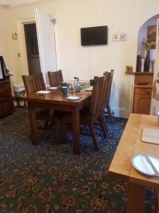 ein Esszimmer mit einem Holztisch und Stühlen in der Unterkunft Cedar Villa Guest House in Inverness