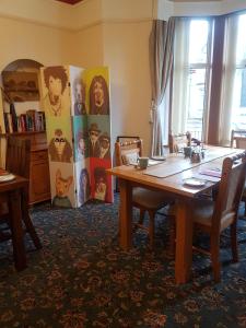 a dining room with a wooden table and chairs at Cedar Villa Guest House in Inverness