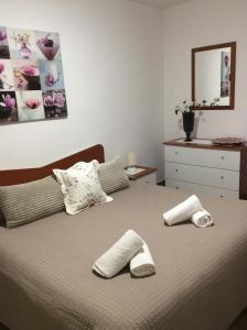 ein Schlafzimmer mit einem Bett mit zwei Hausschuhen darauf in der Unterkunft Casa Vacanze Marinella in Marinella di Selinunte
