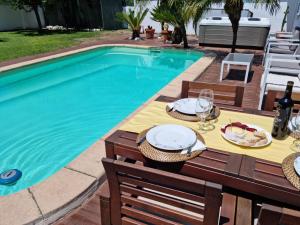 a swimming pool with a table with plates of food on it at Guest House Ruceel Aroeira in Almada