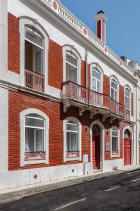 un edificio de ladrillo rojo con ventanas y puerta roja en 1869 Príncipe Real House, en Lisboa