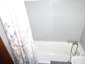 łazienka z zasłoną prysznicową i lustrem w obiekcie Jausiers village A 5 w mieście Jausiers