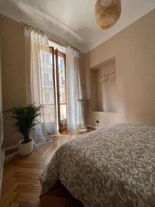 a bedroom with a large bed and a potted plant at La Petite Maison de la Ville in Turin