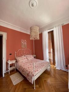 a bedroom with a bed and a chandelier at La Petite Maison de la Ville in Turin