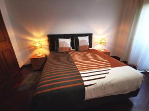 a bedroom with a large bed with two lamps at The Market Square House in Faro