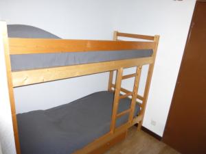 een stapelbed in een kleine kamer met een ladder bij Jausiers village A 5 in Jausiers