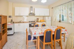a kitchen with a table and chairs and a kitchen with white cabinets at House Sun and Sea in Olib