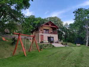 uma casa com um parque infantil em frente em Krisztina Vendégház Leányfalu - Különálló - itt csak Ti vagytok em Leányfalu