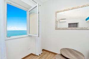 a room with a window and a table and a mirror at Queen of Sea Diamond, Terre Marine in Manarola