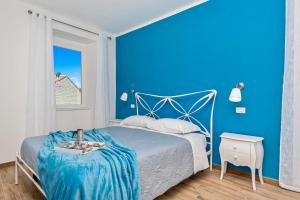 a blue bedroom with a bed with a blue wall at Queen of Sea Diamond, Terre Marine in Manarola