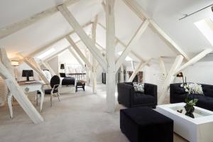 un soggiorno con soffitti bianchi e mobili neri di Clarance Hotel Lille a Lille