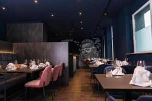 a dining room with tables and chairs and a mural of a chef at Hotel Monopol in Hilden