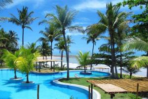 un complejo con piscina y palmeras en Casa do Pescador, en Praia do Espelho