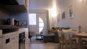 a kitchen and living room with a table and a couch at Le RepOzoir, une halte entre Paris et Disneyland in Ozoir-la-Ferrière