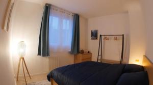 Ozoir-la-FerrièreにあるLe RepOzoir, une halte entre Paris et Disneylandの青いベッドと窓のある寝室