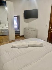 a bedroom with a white bed with a television on the wall at Il Bijoux in Celano