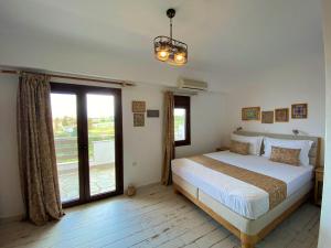 a bedroom with a bed and a large window at Marianna Sea View Afitos in Afitos