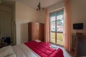 1 dormitorio con 1 cama con manta roja y ventana en HOTEL CONCORDIA, en Montecatini Terme