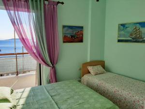 a bedroom with two beds and a window with a view at Μαγευτικο ηλιβασιλεμα Μαρμαρι Ευβοιας in Marmarion