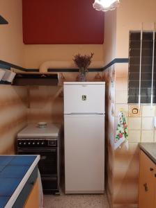 een keuken met een witte koelkast en een fornuis bij Μαγευτικο ηλιβασιλεμα Μαρμαρι Ευβοιας in Marmarion
