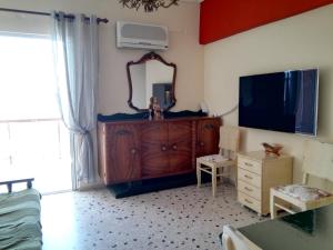 a room with a dresser and a mirror and a television at Μαγευτικο ηλιβασιλεμα Μαρμαρι Ευβοιας in Marmari