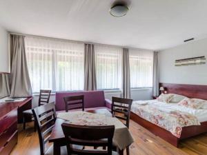 1 dormitorio con 1 cama, mesa y sillas en Apartamenty i pokoje ,,Leśne" en Jastarnia