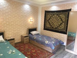 - une chambre avec 2 lits et une tapisserie sur le mur dans l'établissement Sitora Star guest house, à Samarcande