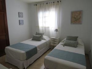 um quarto com 2 camas e uma janela em Mi Paraiso Vacacional, Isla del Hierro. em Tamaduste