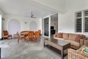 a living room with a couch and a table and chairs at Blue Breeze Apartment in Water Villas in Kralendijk