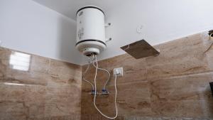 a light on the wall of a shower in a bathroom at Saatvik Homestay with Free Pickup & Drop for Vaishno Devi Yatra in Katra