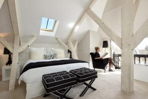 a woman sitting in a chair in a bedroom with a bed at Clarance Hotel Lille in Lille