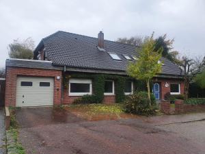 a red brick house with a white garage at FeWo-Brak in Norden