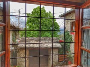 une fenêtre avec vue sur un bâtiment dans l'établissement Archontiko Rapti Stone Traditional House, à Monodendri