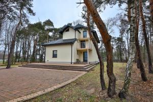 Biały dom w środku lasu w obiekcie Siedlisko Czekaj 15 w Uniejowie