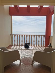 een kamer met een balkon met uitzicht op de oceaan bij Marine Apartments Venetiko in Chios