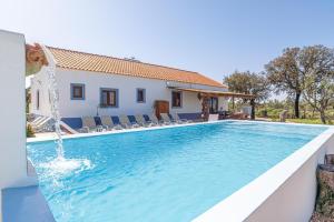 una piscina con una fuente de agua frente a una casa en Villa Casanova en Melides