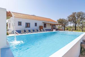 una piscina con una fuente de agua frente a una casa en Villa Casanova, en Melides