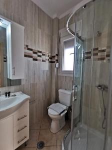 a bathroom with a toilet and a glass shower at Venetiko rooms in Chios +18 photos