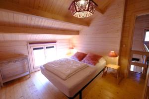 a bedroom with a bed in a wooden cabin at Gîte Cerf'titude in Soy
