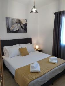 1 dormitorio con 1 cama con 2 toallas en Πλατανακι 2 Seaview Apartment, en Ándros