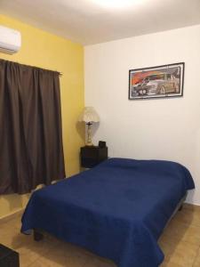 Un dormitorio con una cama azul y una foto en la pared en Casa completa en privada y con cochera, en Monclova