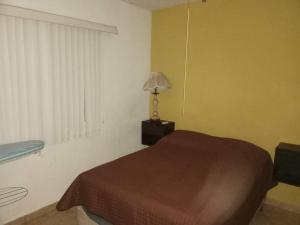 a bedroom with a bed and a lamp and a window at Casa completa en privada y con cochera in Monclova