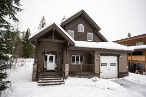 a brown house with snow on the ground at Mountain Gateway by Revelstoke Vacations in Revelstoke
