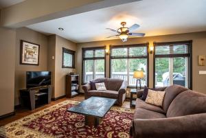 a living room with a couch and a tv at Mountain Gateway by Revelstoke Vacations in Revelstoke