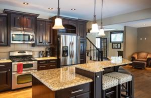 a kitchen with wooden cabinets and granite counter tops at Mountain Gateway by Revelstoke Vacations in Revelstoke